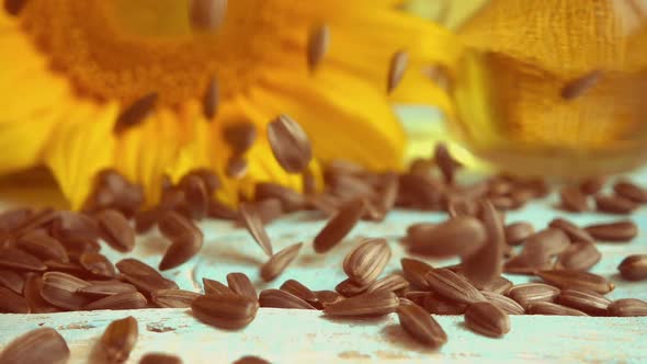 Sunflower, sunflower oil on blue vintage wooden table top and falling sunflower seeds on it