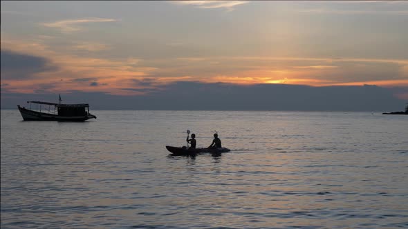 Majestic video of the silhouette of a couple kayaking on the ocean during a beautiful sunset