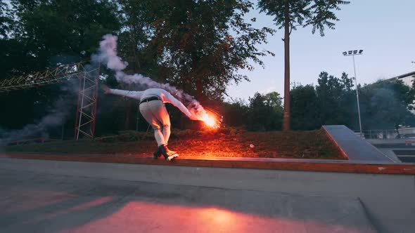 Aggressive Inline Roller Skater Doing Tricks in Concrete Skatepark with Red Burning Signal Flare