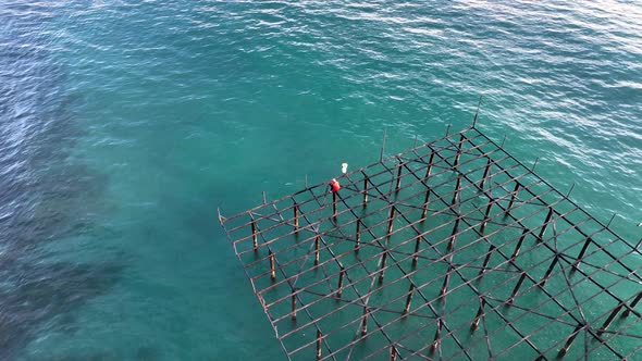 A fisherman catches fish on an old pier