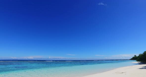 Daytime overhead clean view of a paradise sunny white sand beach and blue ocean background in hi res