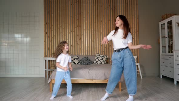 Funny Mum and Curly Haired Daughter Dance and Give High Five