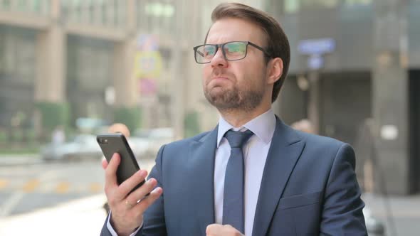 Portrait of Businessman having Loss while using Smartphone, Outdoor