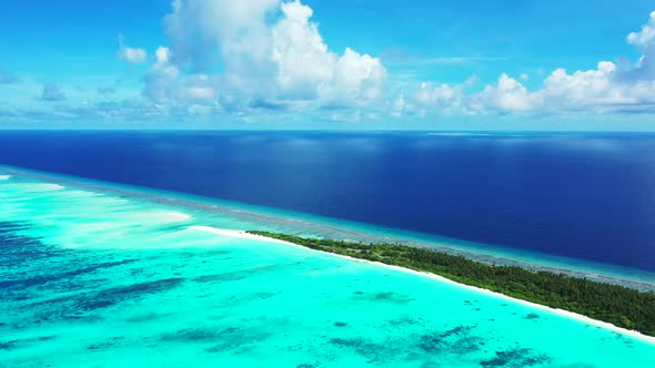 Wide angle flying travel shot of a sunshine white sandy paradise beach and blue sea background in hi