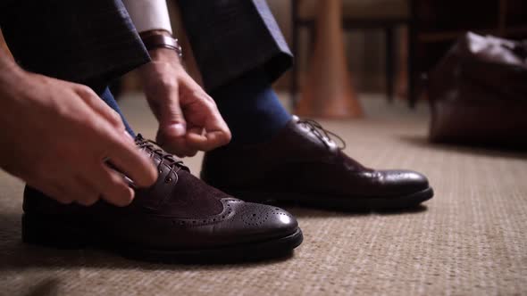 Hands of Man Tying Shoelaces Before Going Out