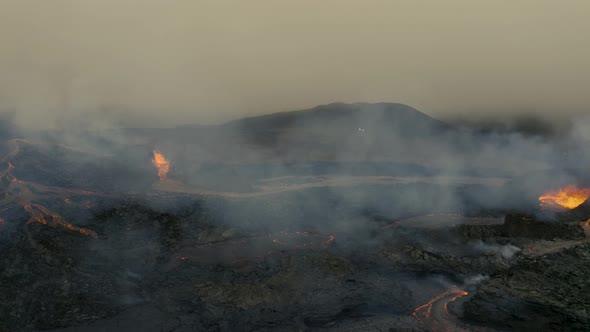 Aerial view of Earth core magma pressing through fissure vents at a volcano basin - tracking, drone