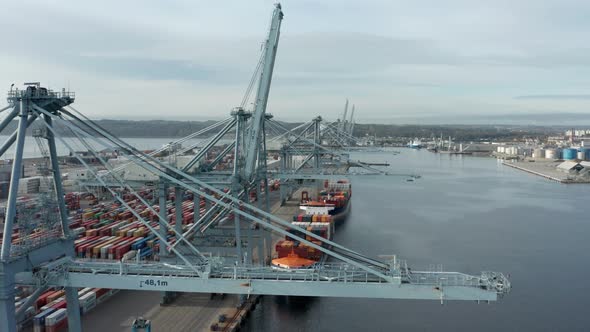 Breathtaking Aerial Drone Shot of Calm Sea and Shipyard Port Against Clear Skie