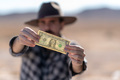 Cowboy with grey hat, moustache and checked shirt holding a dollar bill - PhotoDune Item for Sale