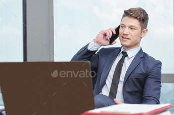 sitting at office table and answering phone call of coworker