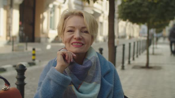 Portrait of Elderly Blonde Woman Looking Directly at Camera Outdoors