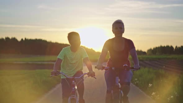 Mom and Son on a Sunset Walk on Bicycles