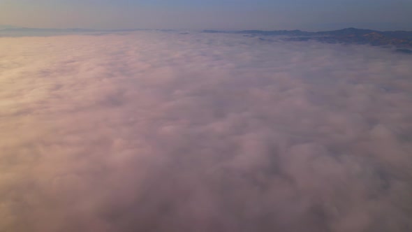 4K Aerial video Beautiful sunrise above dense clouds and fog in the morning