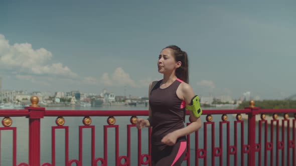 Sporty Woman Walking Fast on Bridge After Jogging