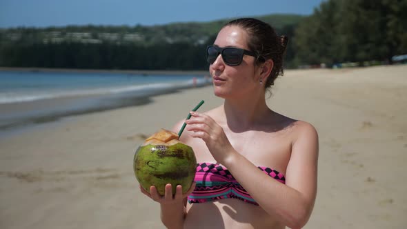 Woman Drinks Coconut Juice Using Straw and Enjoys Vacation