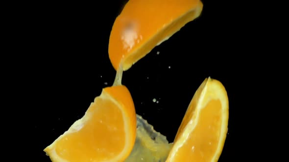 Super Closeup Slices of Orange Bouncing with the Drops of the Orange Juice