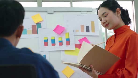 Young Woman Explains Business Data on White Board