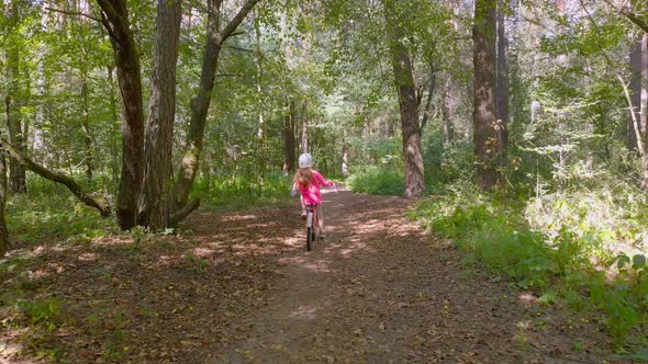 Little Girl On Bicycle In Forest