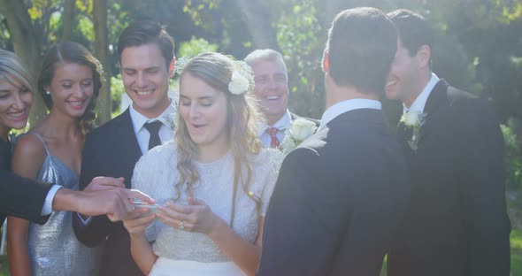 Happy bride, groom and family checking photographs 4K 4k