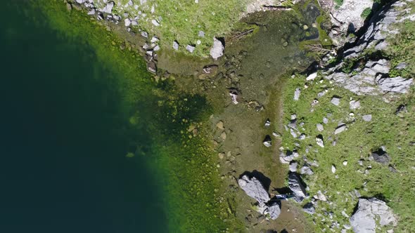 top down view of guy relaxing in a hammock at a mountain lake in the swiss alps