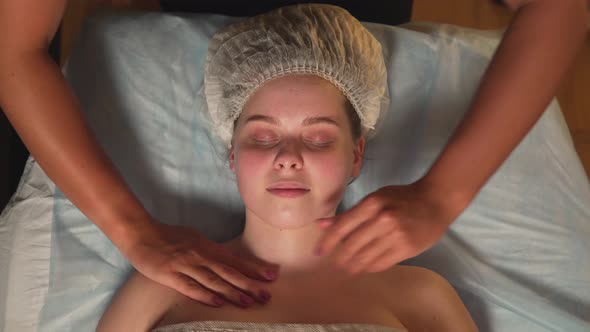 A Beautiful Young Woman Enjoys a Neck Massage at a Beauty Clinic