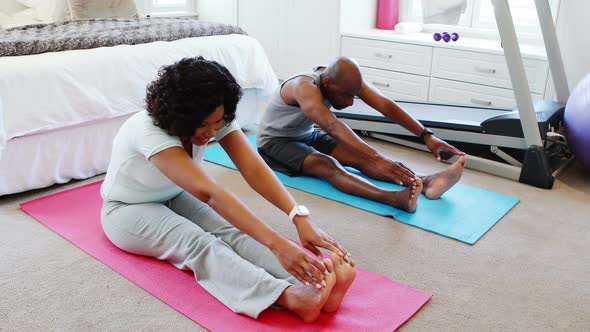 Couple exercising together on exercise mat 4k