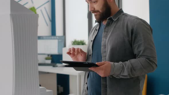 Close Up of Engineer Using Tablet to Design Building Model and Maquette at Work