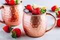 Refreshing iced Moscow mule alcoholic cocktail in copper mugs with strawberry and lemon - PhotoDune Item for Sale