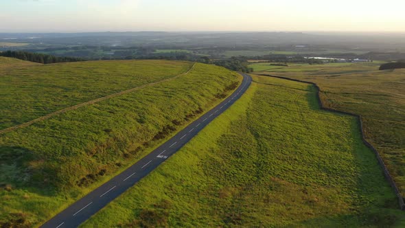 An aerial shot of an empty road in the English countryside