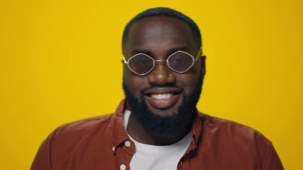 Portrait of Smiling African American Man Dancing on Yellow Background