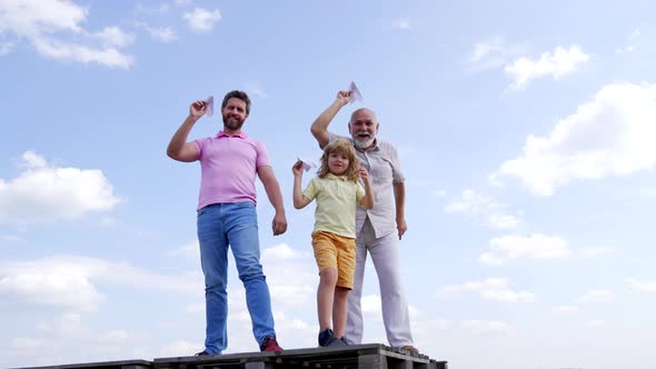 Happy Family of Boy Son and Old Man Grandfather Hold Paper Planes Standing Skyhigh Freedom