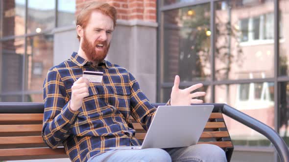 Online Shopping Failure for Redhead Beard Young Man Sitting on Bench
