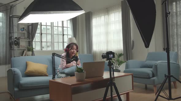 Asian Girl Vlogger Sing A Song During Streaming. Professional Light Equipment