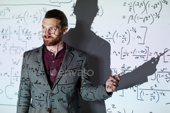 cket standing against projection screen and pointing at formula while explaining calculations