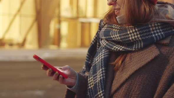 Woman Typing on Smartphone Outdoors in Evening