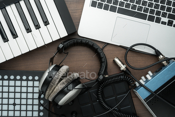  such as laptop, midi keyboard, reference studio headphones, audio recording sound card with cables and pad controllers.