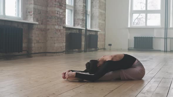 Graceful Ballerina Doing Stretching Exercises On Floor