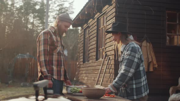 Man and Woman Preparing Food for Cooking on Barbecue