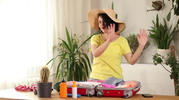 Happy Woman in Hat Dancing Packing Suitcase Getting Ready for Summer Vacation