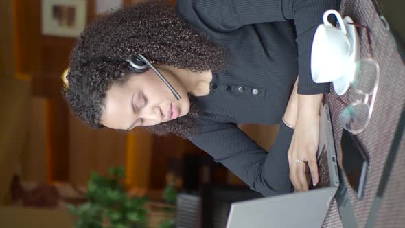 Vertical Video - African-american Woman with a Laptop Is Having an Online Conversation.