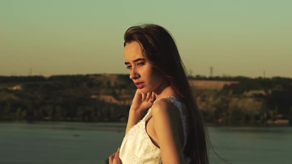 Girl in the Background of a River and Greenery Looking Into the Distance. Slow Motion