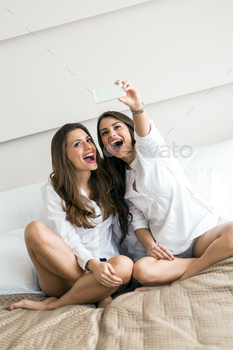  of themselves with a phone in a luxorious bedroom