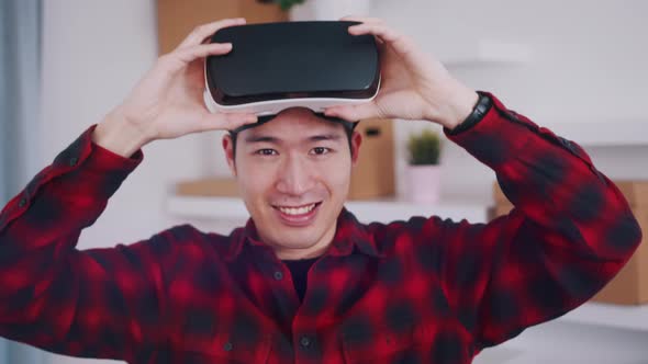 Asian Young Man Removing VR Headset From Hs Eyes and Smiling