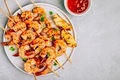 Sweet Chili Shrimp Skewers with lemon and parsley on gray stone background - PhotoDune Item for Sale