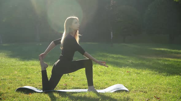 Young Woman Practices Yoga at Park. Healthy Lifestyle Concept