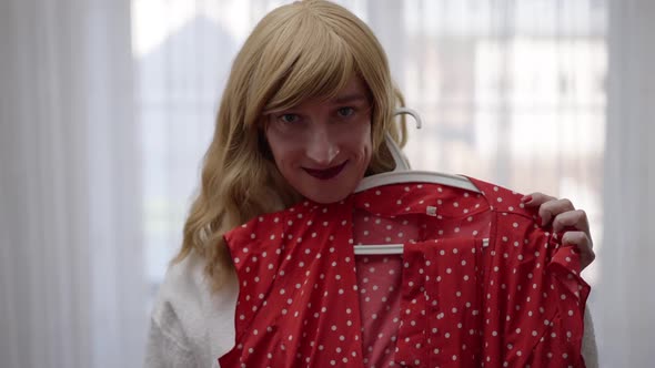 Portrait of Positive LGBTQ Trans Woman Bragging New Red Dotted Dress Looking at Camera Smiling