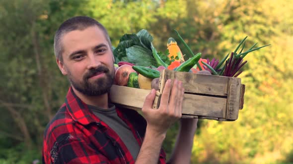 Farmer Walks with wooden Box full of Vegetables