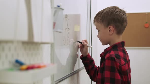 Boy Pupil Draws on the Chalkboard While Studying at School