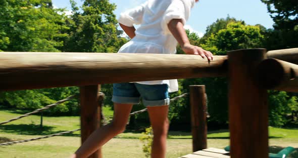 Girl playing on a playground ride in park