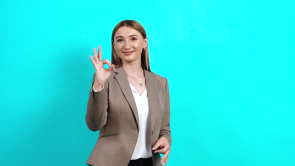 The Happy Young Woman Shows a Gesture with Her Hand To Say That She Feels Good