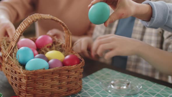 Little Girl Decorating Easter Eggs with Family